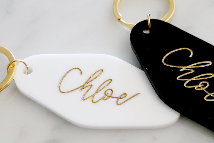 black or white custom motel keychain with gold lettering
