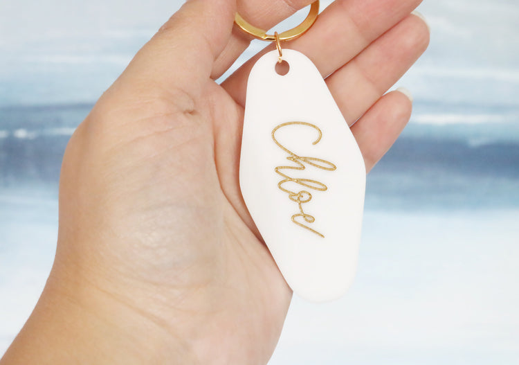 black or white custom motel keychain with gold lettering